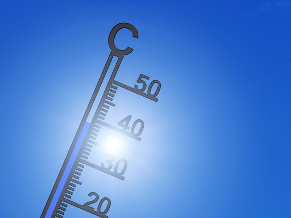 Ein Thermometer vor einem blauen, wolkenlosen Himmel zeigt 39° Celsius, während die Sonne im Hintergrund scheint.